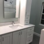 A bathroom with white cabinets and counter tops, perfect for a bathroom remodel.