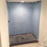 A bathroom remodel is underway, with the walls being repainted a soothing blue color.