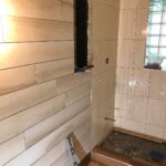 A bathroom with wooden walls and a shower.