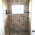 A bathroom with tile floors and a window, ideal for a bathroom remodel.