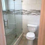 A bathroom with a glass shower stall and toilet, perfect for a bathroom remodel.