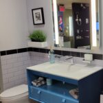 A bathroom with a blue sink and mirror. The blue sink and mirror add a unique touch to the bathroom design, enhancing the overall aesthetic.