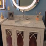 A bathroom vanity with a mirror and a cabinet.
