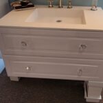 A white bathroom vanity with two drawers and a mirror, perfect for a bathroom remodel.