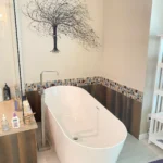 A white bathtub with a tree on it, placed on a bathroom countertop.