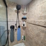 A luxurious bathroom remodel featuring a stunning tiled shower, complete with fluffy towels hanging on the wall.
