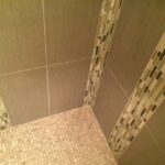 A stylish shower with a tiled floor and tiled walls, perfect for any bathroom design.