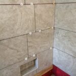 A bathroom remodel with a tiled shower and red walls.