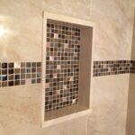 A beautifully designed bathroom remodel featuring a tiled shower with a convenient tiled shelf for added functionality.