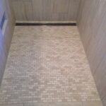 A shower with tiled floor and tiled walls, perfect for a bathroom remodel.