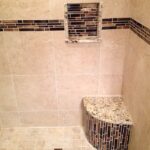 A shower with a bench and tiled walls, perfect for a luxurious bathroom design.