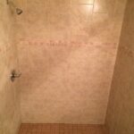 A tiled shower with a tiled floor, showcasing a stylish bathroom design.