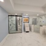 A bathroom with marble floors and a walk in shower.
