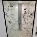 A black and white shower with a glass door, perfect for a bathroom remodel.