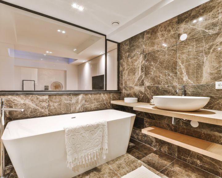 A bathroom with marble walls and a bathtub, featuring a luxurious bathroom design.