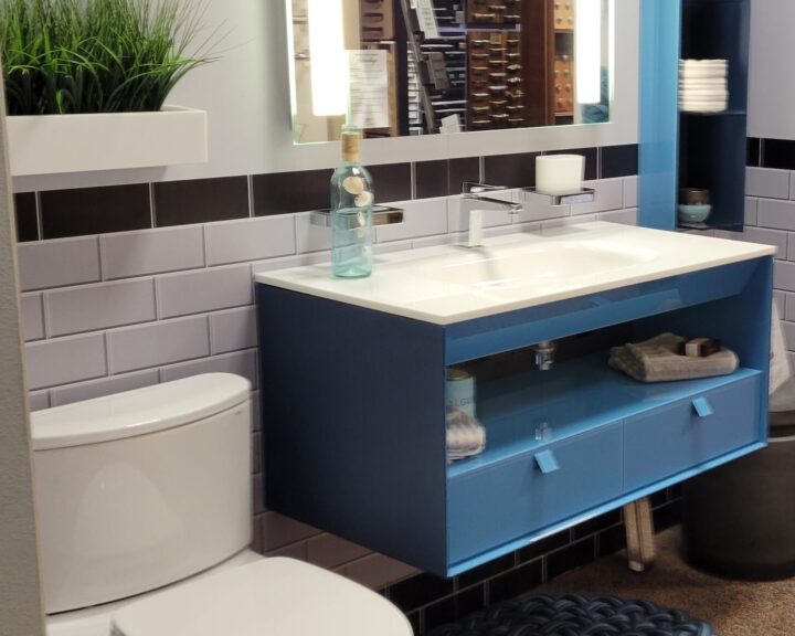 A bathroom with a toilet and sink, featuring a stylish bathroom design.