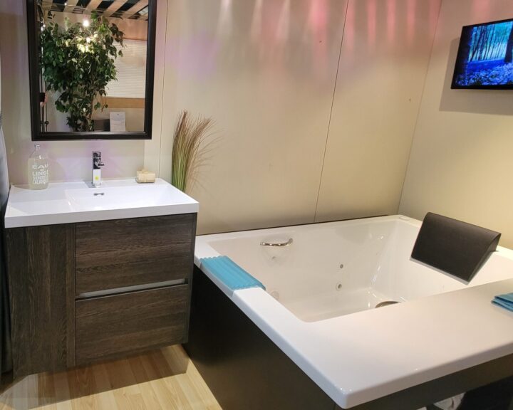 A bathroom with a jacuzzi tub and sink featuring a bathroom countertop.