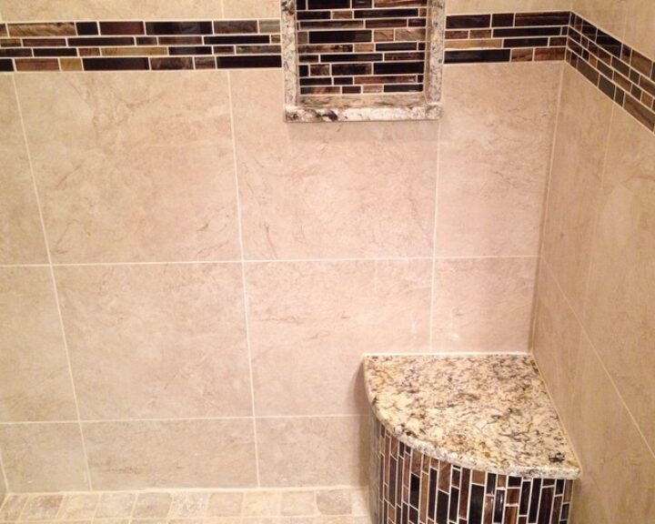 A shower with a bench and tiled walls, perfect for a luxurious bathroom design.