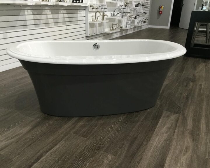 A bathtub sitting on a wooden floor in a store, showcasing bathroom design.