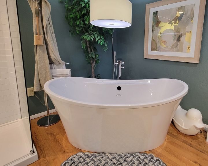 A white bathtub in a bathroom with green walls, creating a refreshing bathroom design with a touch of natural ambiance.