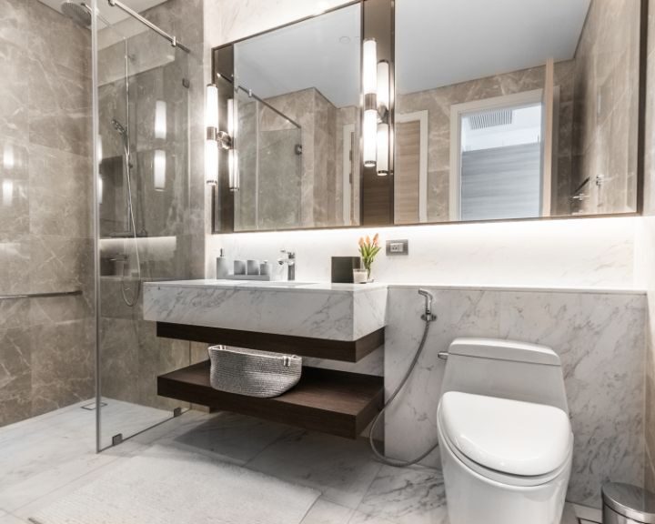 A marble bathroom with a toilet, shower, and bathtub.