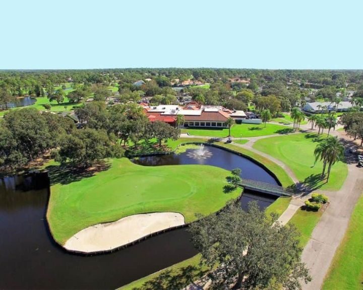 An aerial view of a golf course with a pond and bathroom remodel design.