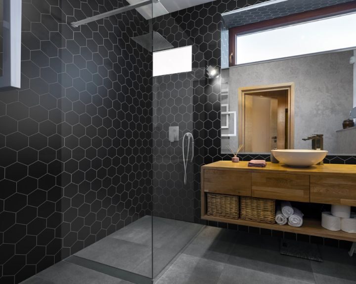 A bathroom with a wooden vanity and black hexagonal tiles, perfect for a modern bathroom design or remodel.