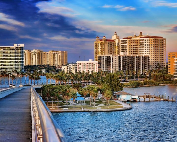 A bridge over a body of water with buildings in the background, perfect for a scenic stroll or photo opportunity.