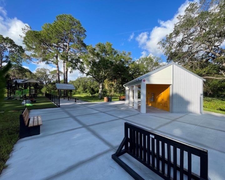 A playground with benches and a storage shed.