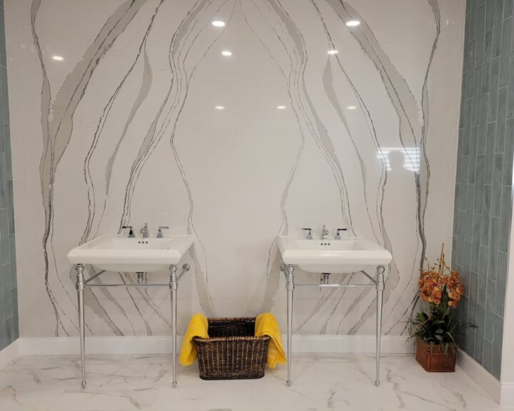 A bathroom with two sinks and a marble wall.