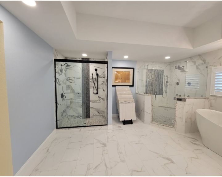 A walk-in shower with marble floors adds a touch of luxury to this bathroom remodel.