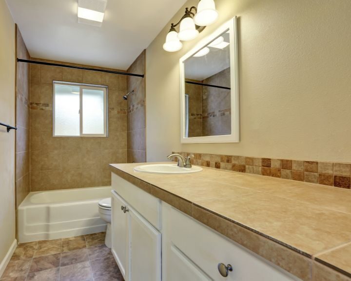 A bathroom with tile floors and a sink, undergoing a bathroom remodel.