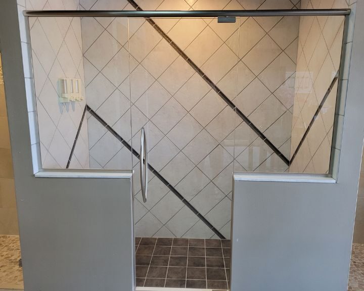 A glass shower door in a bathroom remodel.