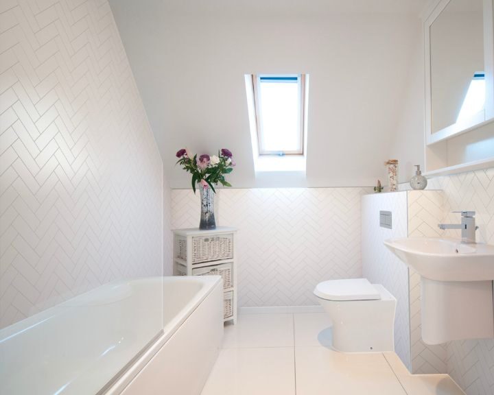 A white tiled bathroom with a skylight, perfect for a bathroom remodel.
